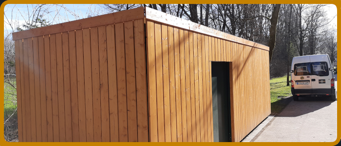 Verkleidung eines Mülltonnenhauses in Massivholz lasiert