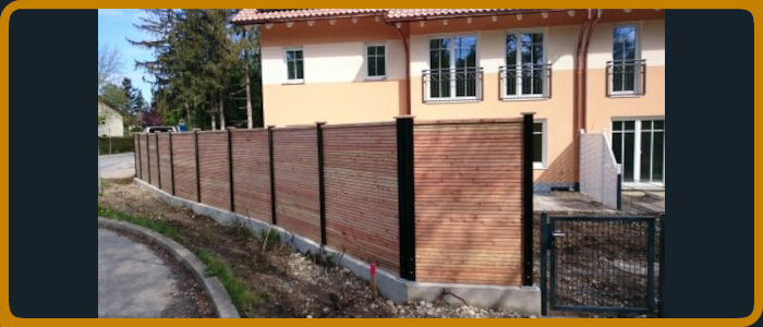 Sichtschutzzaunbau mit schwarzen Stehern und Lärche Füllungsbretter Natur